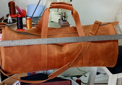 Custom-made, light brown leather duffle bag within custom made realization