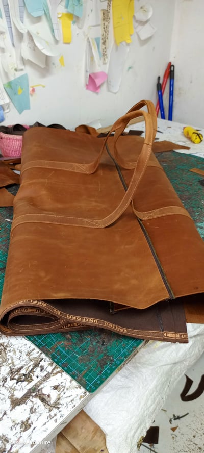 Custom-made, light brown leather duffle bag within custom made realization